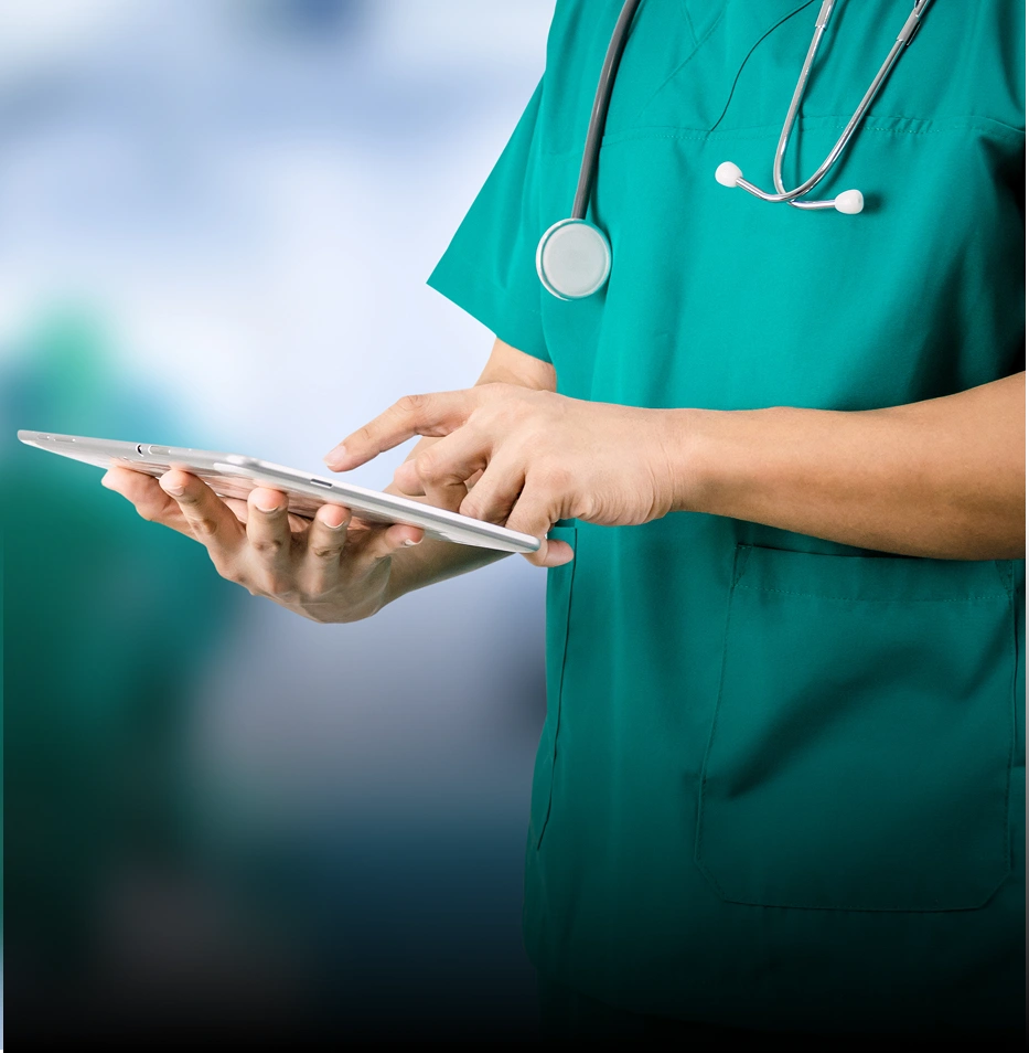 Healthcare professional in scrubs using tablet, illustrating digital tools in patient care. 