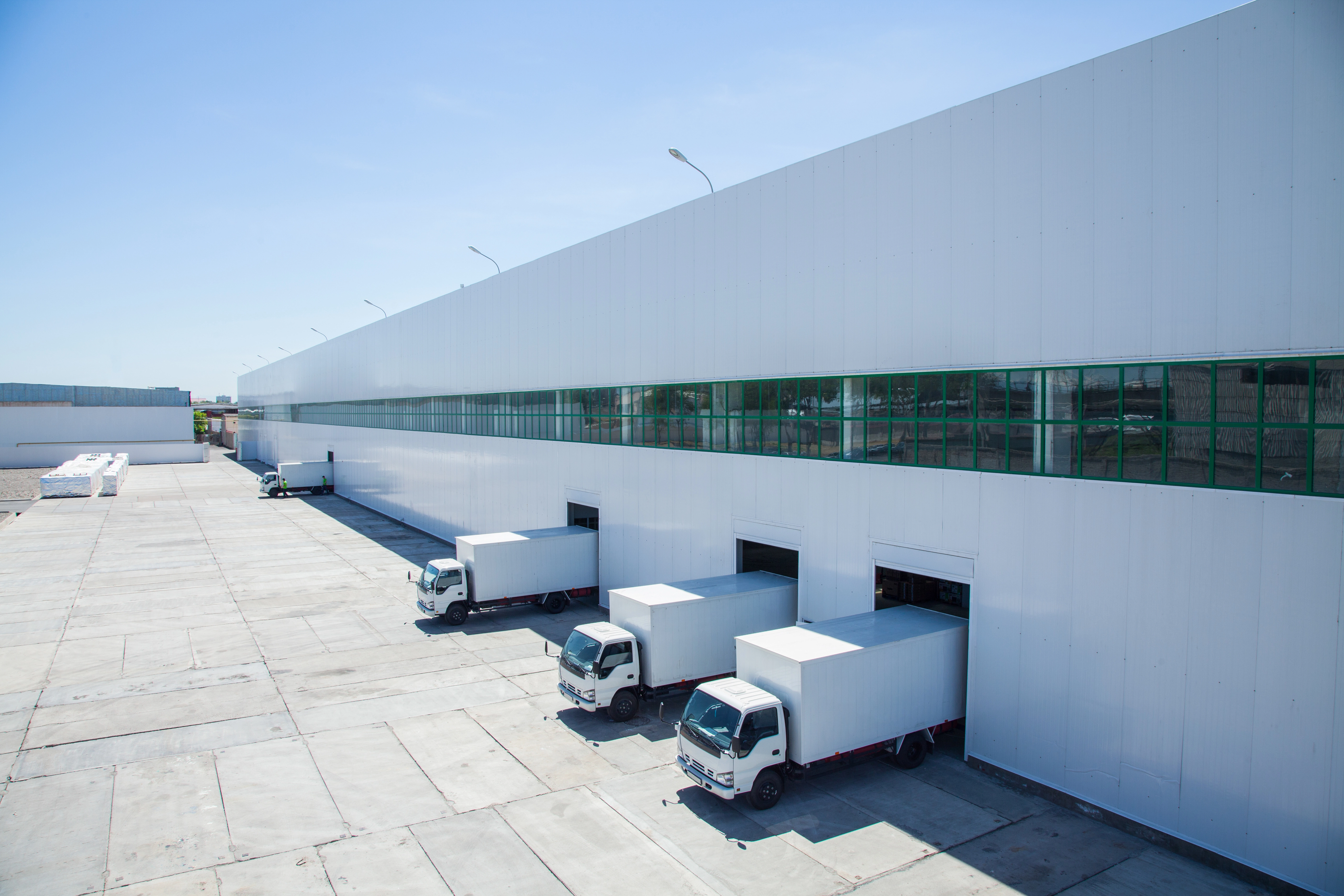 Delivery trucks lined up for loading and unloading at a warehouse.