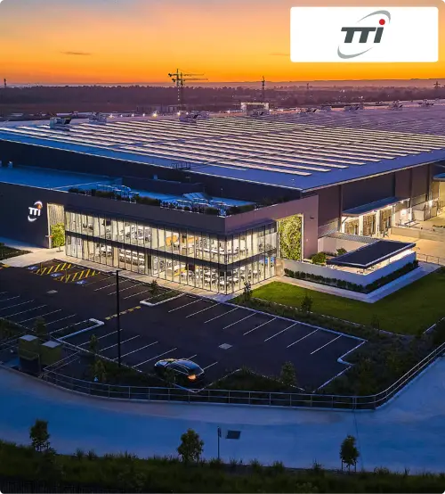 Sunset over an industrial facility with the TTI logo. Text highlights a case study showing $2M savings through automated workflows, noting a switch from Honeywell to Almasons GiNi. 
